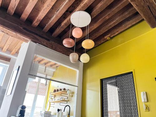 a group of lights hanging from a ceiling at Les Appartements d Aristide Avallon in Avallon