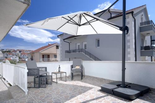 a white umbrella sitting on top of a balcony at Apartments Bodlovic - ZF Hvar in Hvar