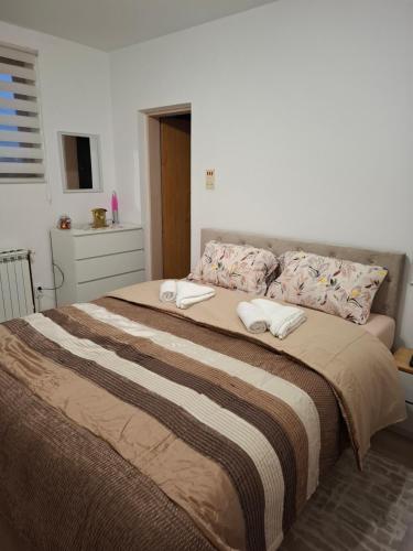 a bedroom with a large bed with two towels on it at AMADA apartman in Vranješ