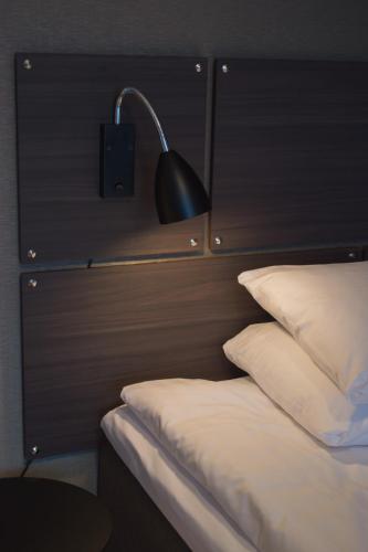 a black lamp sitting on the headboard of a bed at Best Western Plus Park Airport Hotel in Arlanda