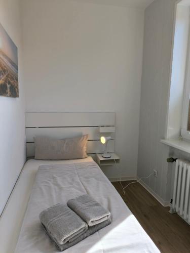 a bedroom with a bed with two towels on it at Wind und Meer in Langeoog