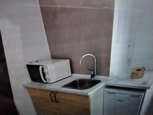a small kitchen with a sink and a microwave at Kiriki rooms in Camas