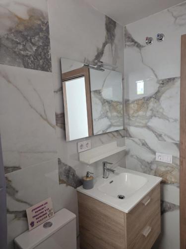 a bathroom with a sink and a mirror and a toilet at Kiriki rooms in Camas
