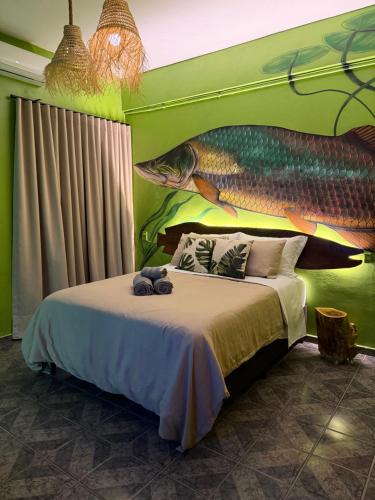 a bedroom with a bed with a painting of a fish at Morada do Boto in Santarém