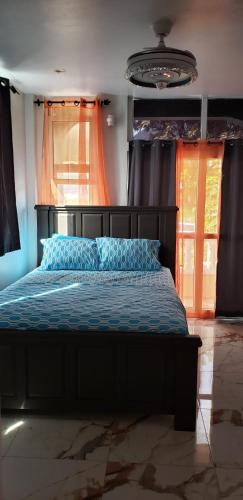 a bedroom with a bed with blue sheets and a window at Azille's Apt in Portsmouth
