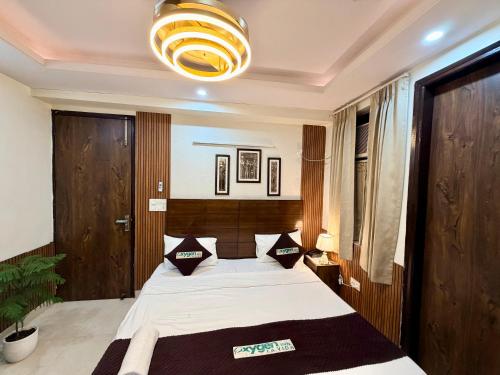 a bedroom with a bed and a chandelier at Hotel Oxygen La Vida-Noida Sector 18 in Noida