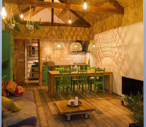 a kitchen with a table and green chairs in a room at Balistyle guesthouse incl Hottub near Amsterdam and Haarlem in Velsen-Zuid