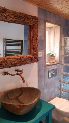 a bathroom with a stone sink and a toilet at Balistyle guesthouse incl Hottub near Amsterdam and Haarlem in Velsen-Zuid