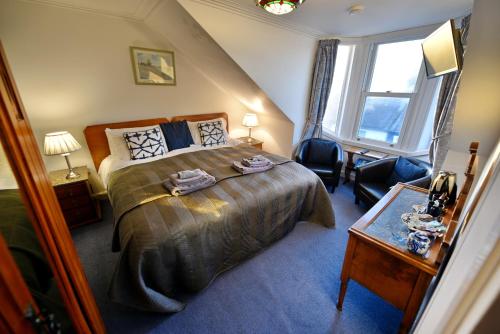 a bedroom with a large bed and a window at Burnside Guest House in Ayr