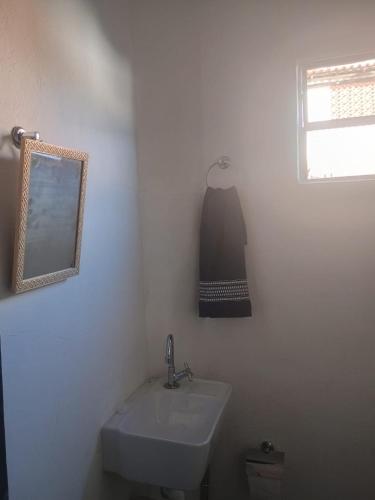 a white bathroom with a sink and a mirror at Hospedagem Campestre da Dutra 01 in Barra Mansa