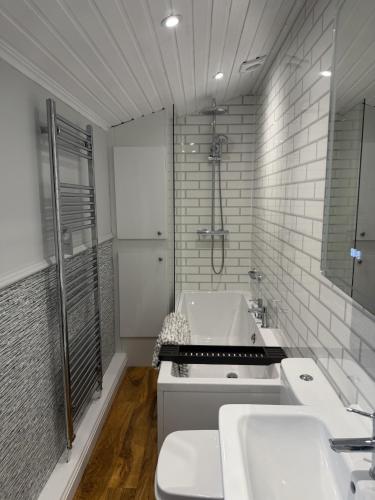 a bathroom with two sinks and a bath tub at Wharfe Lodge - complimentary spa access in Skipton