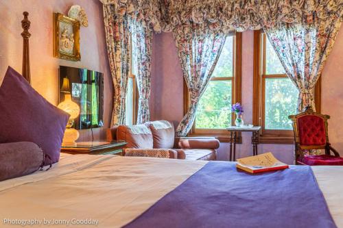 a bedroom with a bed and a large window at Cliff Cottage Inn, Downtown Bed & Breakfast in Eureka Springs