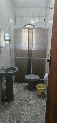 a bathroom with a shower and a toilet and a sink at Chácara Segatelli in Cotia