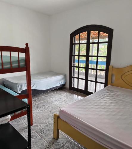 a room with two beds and a window at Chácara Segatelli in Cotia