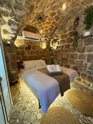 a bedroom with two beds in a stone wall at Calamari Suite in Acre
