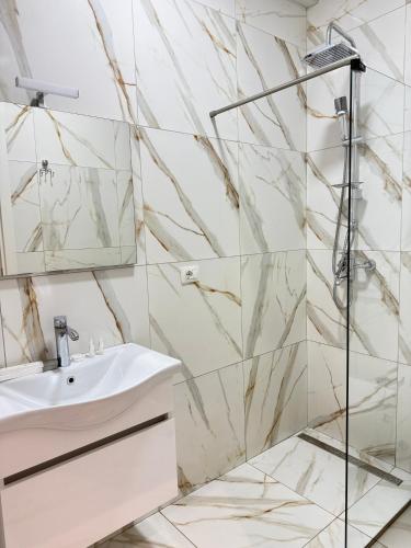 a bathroom with a sink and a shower at Hotel Apart Odeon in Durrës