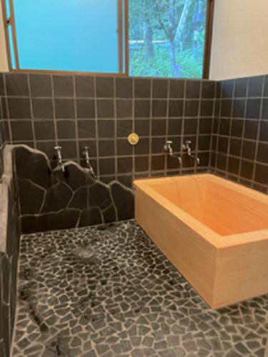 a bathroom with a tub with a black tiled floor at kohagino - Vacation STAY 12342 in Uenohara