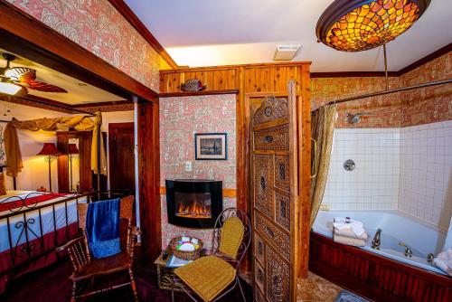 a bathroom with a bath tub and a fireplace at Cliff Cottage Inn, Downtown Bed & Breakfast in Eureka Springs