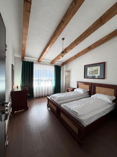a large bedroom with two beds and a window at Cabana Piatra Buru in Buru