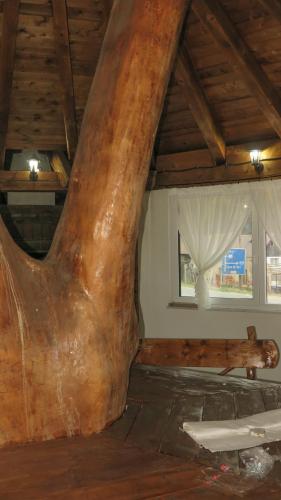 a room with a large tree stump in the ceiling at Cabana Piatra Buru in Buru