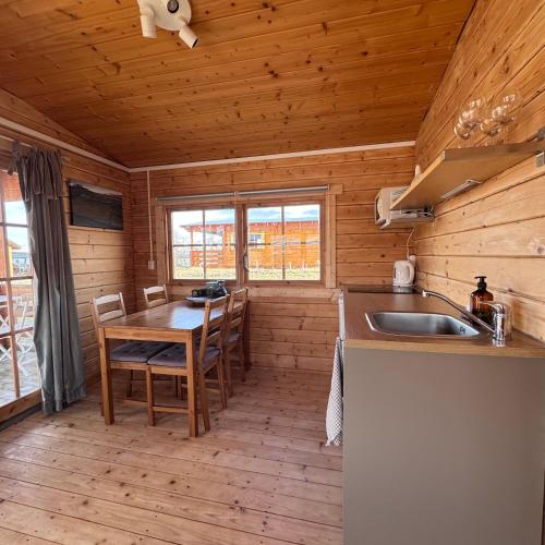 a kitchen with a table and a sink in a cabin at Armuli in Reynistaður