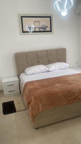 a bedroom with a large bed with a brown blanket at Golem luxury apartment in Golem