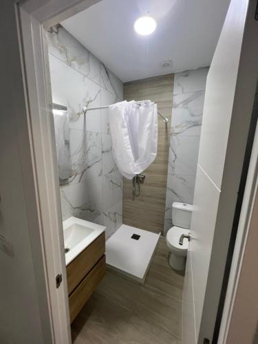 a white bathroom with a sink and a toilet at Apartamento en el centro vinaros in Vinarós