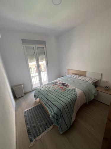 a bedroom with a bed with a green blanket at Apartamento en el centro vinaros in Vinarós