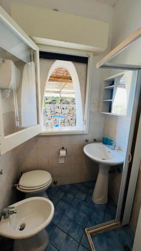 a bathroom with a sink and a toilet and a window at Mare Infinito in Pantelleria