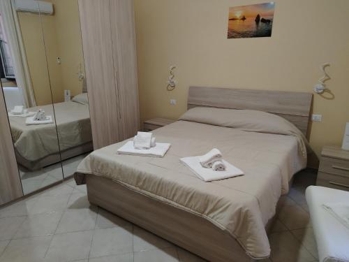 a bedroom with a bed with two towels on it at Sicilian Room in Catania