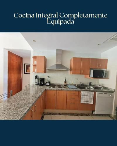 a kitchen with wooden cabinets and a counter top at Lujoso Departamento con vista a alberca en Acapulco Diamante in Acapulco