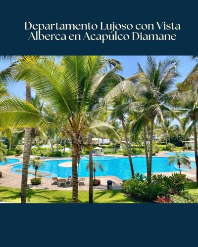 a resort with a swimming pool and palm trees at Lujoso Departamento con vista a alberca en Acapulco Diamante in Acapulco