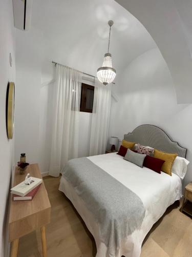 a bedroom with a large bed and a table at Jerez Centro Alojamiento Boutique in Jerez de los Caballeros