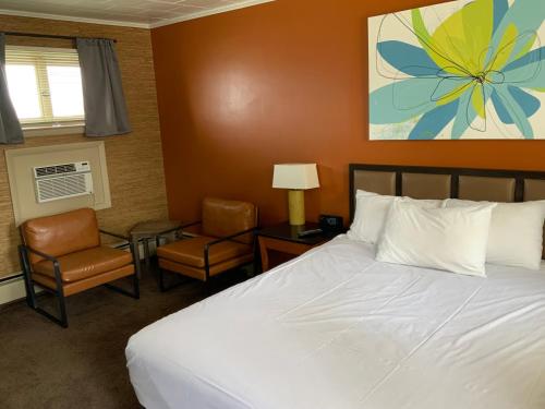 a bedroom with a bed and two chairs and a table at The Triangle Motel in Alma