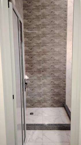 a shower with a glass door in a bathroom at casabianca north coast villa code 112 in Dawwār Muḩammad Abū Shanab