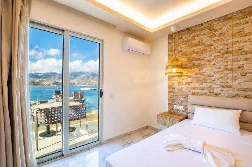 a bedroom with a bed and a large window at Dolphin Hotel Apartments in Karpathos