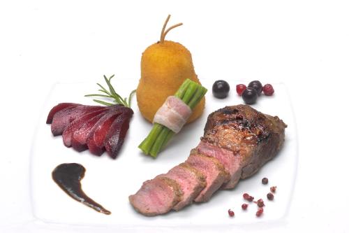 a white plate with meat and vegetables on it at Hotel-Restaurant Im Goldenen Grund in Körperich