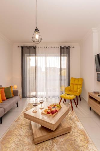 a living room with a table and yellow chairs at LS Beach House in A dos Cunhados