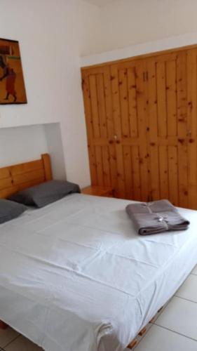 a white bed in a room with wooden cabinets at Carla Tryana Fernandes Castro in Vila do Porto
