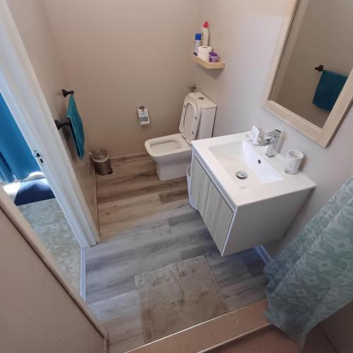 a bathroom with a white sink and a toilet at Sam & Chlo Studio & Appartment - Grand Baie - Mauritius in Grand-Baie
