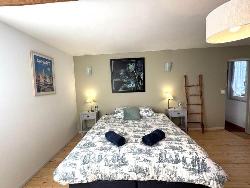 a bedroom with a bed with two pillows on it at La Halte de la Hunière - Jardin - Central - Garage in Vimoutiers