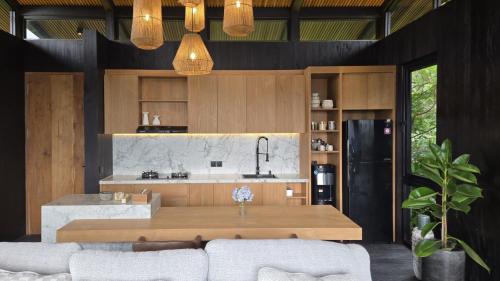 a kitchen with a wooden table and a counter top at The Bataran Cabin in Gitgit