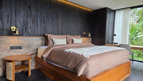 a bedroom with a large bed and a wooden wall at The Bataran Cabin in Gitgit