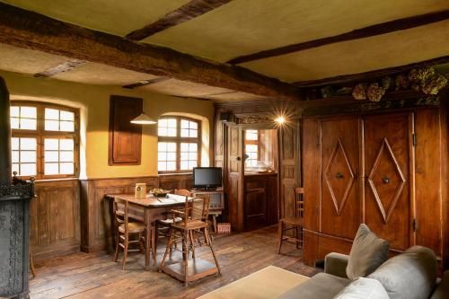 a living room with a table and a dining room at La Ferme de Marie in Rangen