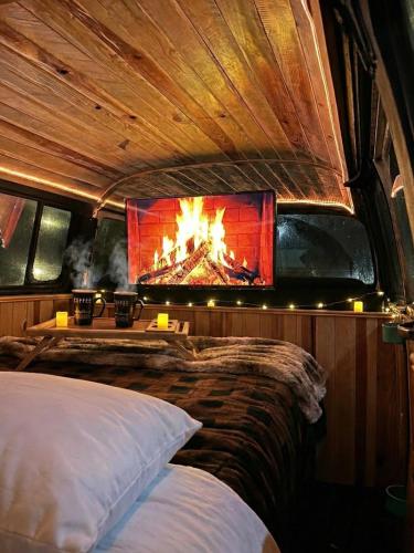 a bedroom with a fireplace in the back of a boat at Biciting Combi Love Glamping with Jacuzzi and Views in Mineral del Chico