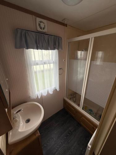 a bathroom with a sink and a shower and a mirror at Holiday Home Arbroath in Arbroath