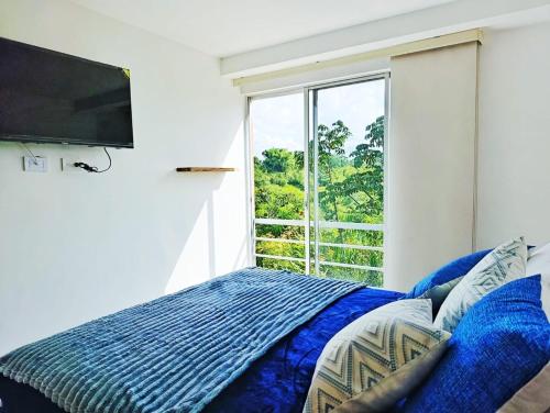 a bedroom with a bed and a large window at Hospedaje en Montenegro Vivienda Turística Cafecito in Montenegro