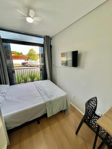 a bedroom with a bed and a window and a chair at Studio Garten Container in Joinville