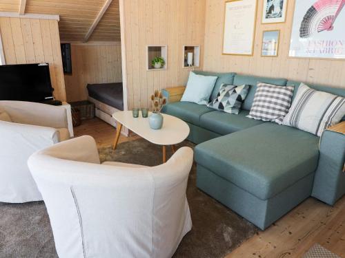 a living room with a blue couch and chairs at 4 star holiday home in Hadsund in Hadsund
