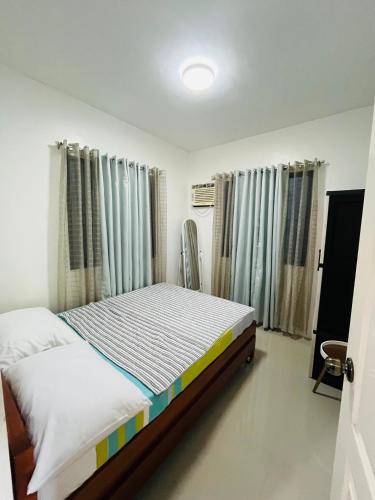 a bedroom with a bed in a room at Akina 2bedroom Transient House in Kabankalan